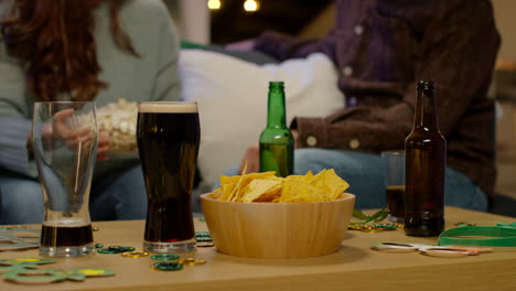 Close-Up-Of-Friends-At-Home-Celebrating-At-St-Patrick's-Day-Party-Drinking-Alcohol-And-Eating-Popcorn-3